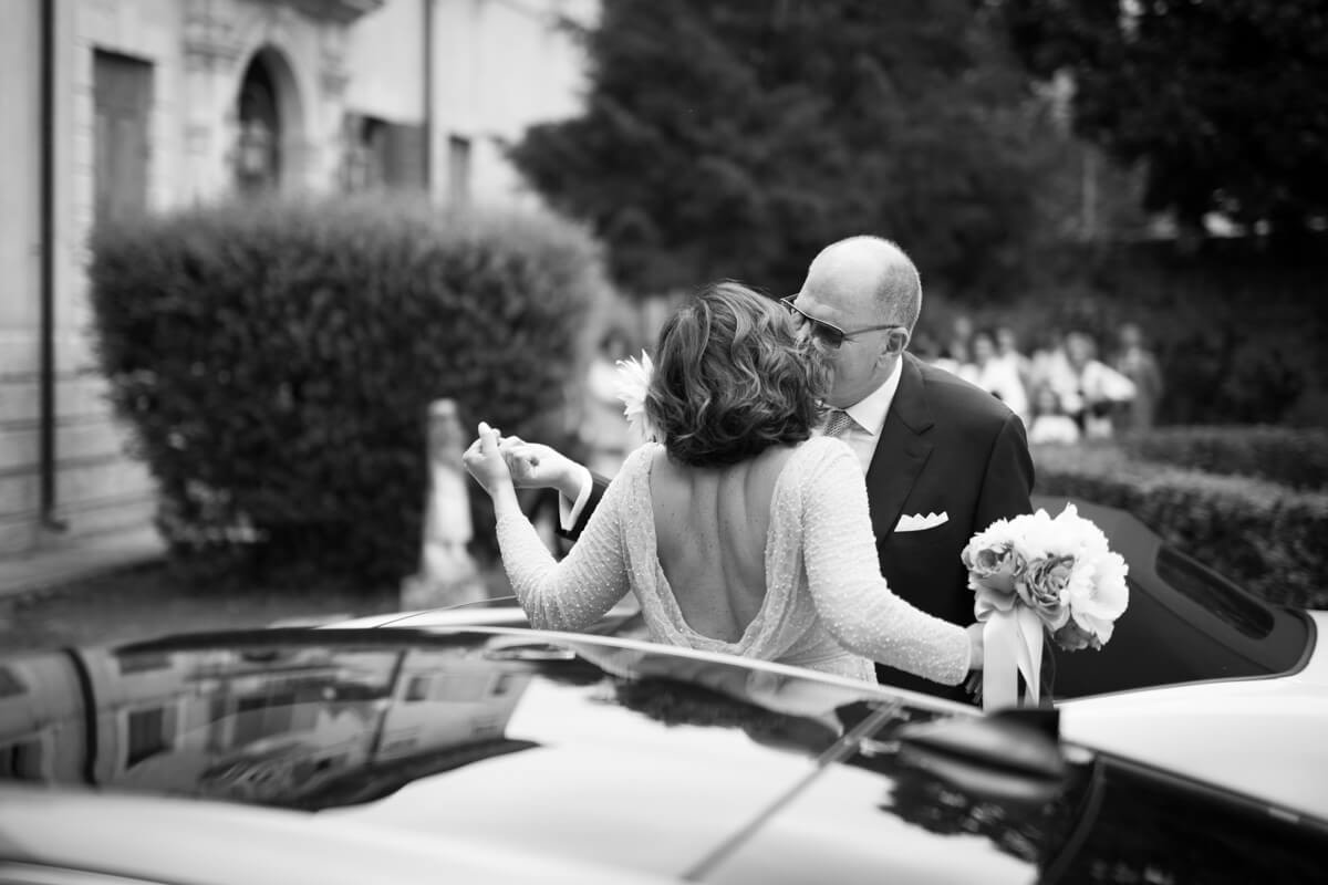 sposo bacia la sposa arrivata in macchina