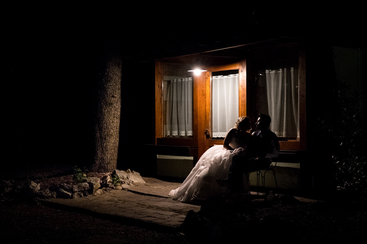 gli sposi seduti su una panchina di notte si guardano