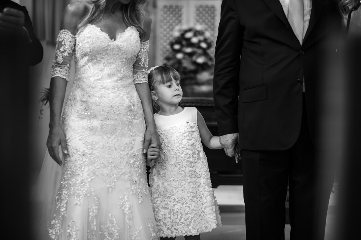 la sposa tiene insieme allo sposo in mano la bambina damigella