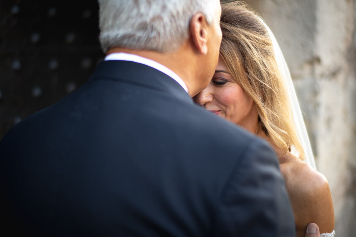 lo sposo mentre bacia sulla fronte la sposa