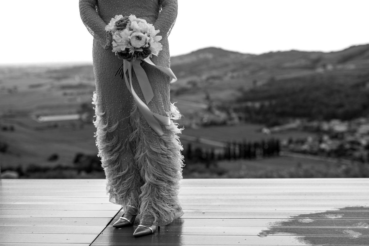 sposa con abito vintage con il bouquet con un bel panorama alle spalle