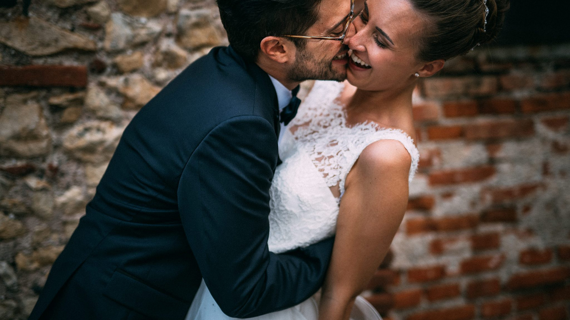 lo sposo abbraccia divertito la sposa mentre ride