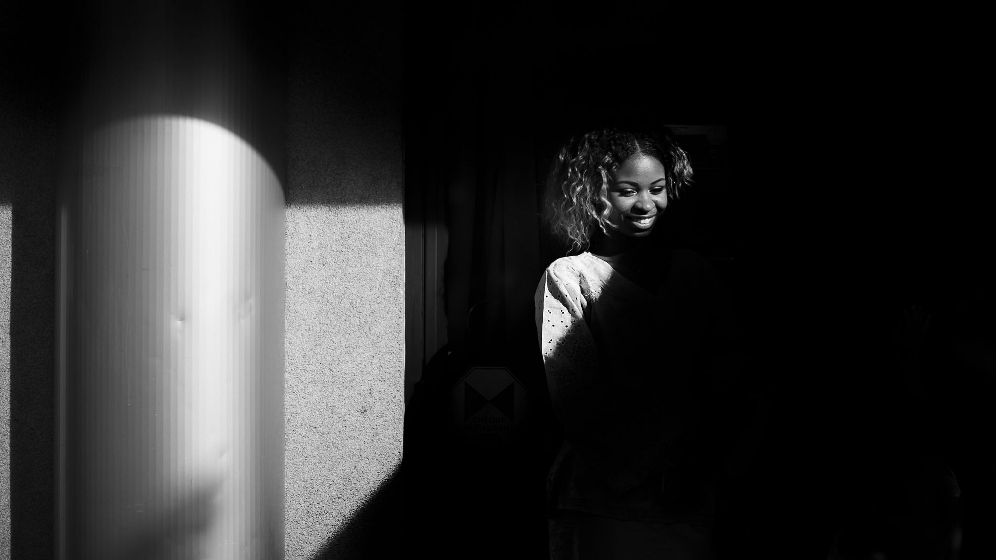 una ragazza nascosta dall'ombra sorride divertita