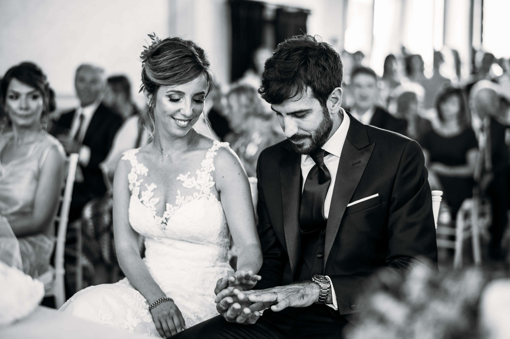 la sposa felice guarda la mano dello sposo con la fede davanti all'altare