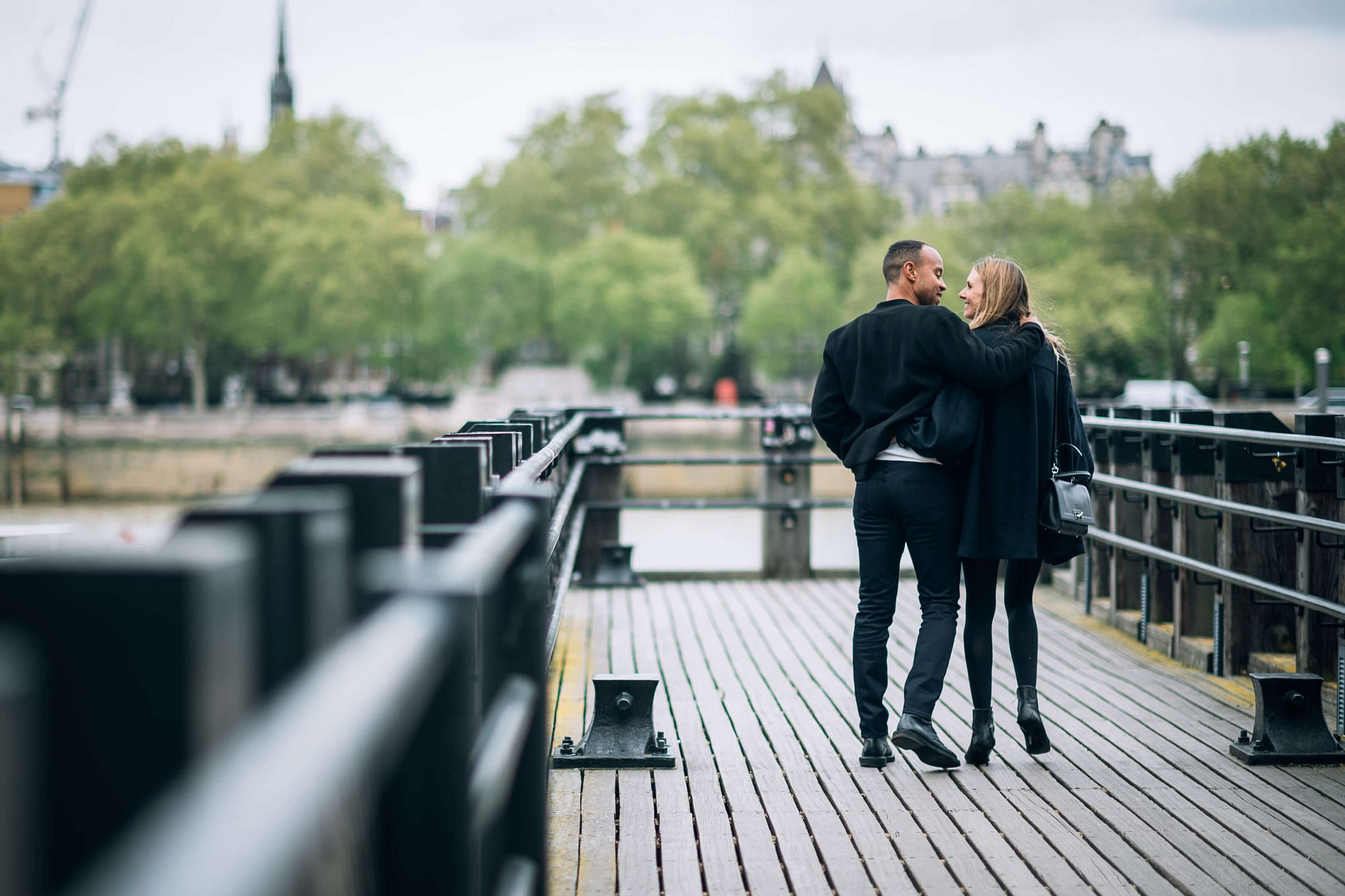 due fidanzati passeggiano sopra un ponte della città di Londra