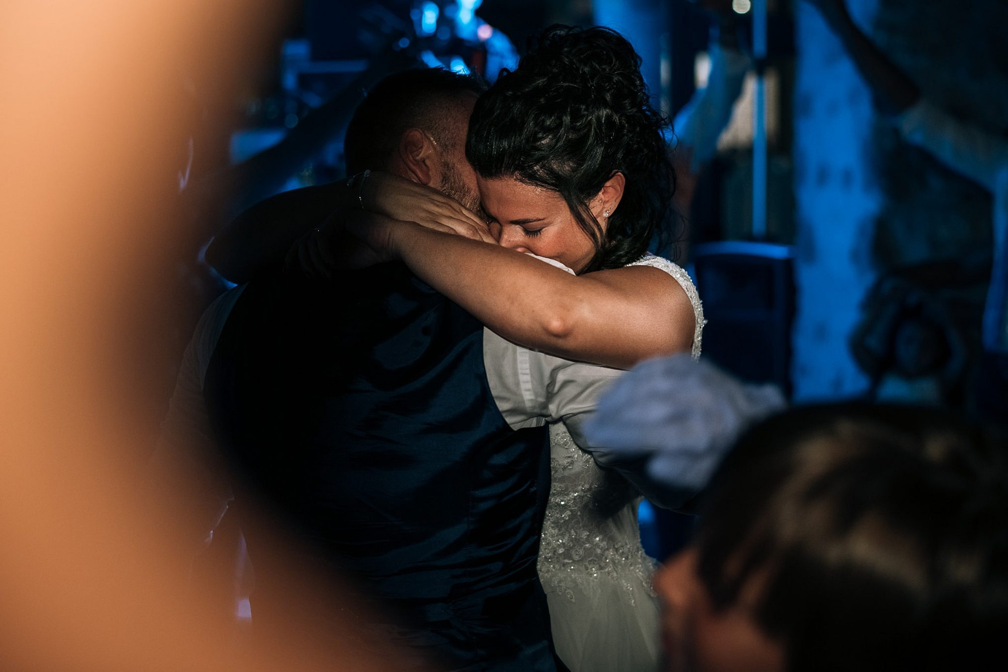 la sposa abbraccia lo sposo commossa mentre ballano al ricevimento