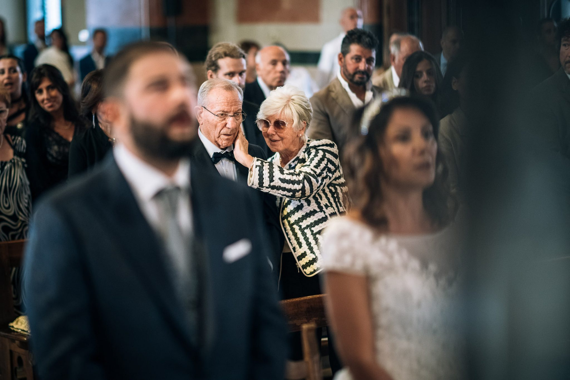 una coppia di invitati anziani si scambia una carezza durante la cerimonia